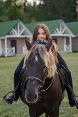 beautiful girl with horse walking in park in summer. equestrian sport