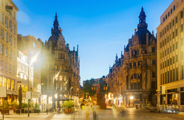 Fototapeta premium Evening view of illuminated Leysstraat street in Belgian city of Antwerp overlooking statue of Flemish baroque painter David Teniers Younger 