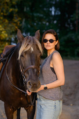 Fototapeta premium beautiful girl with horse walking in park in summer. equestrian sport