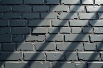 A black brick wall with a distinct pattern, arranged horizontally and accentuated by sunlight casting diagonal shadows, showcasing its simplicity and elegance.