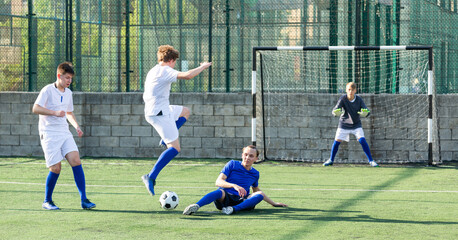Obraz premium Teens playing soccer football match. Competition between two youth soccer teams. Football soccer tournament