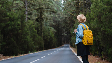 Woman on road through green forest on Tenerife, El Teide National Park, Canary Islands, Spain
