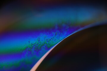 Bright rainbow spots of liquid on black background, blue colours, surrealistic pattern, fantastic smooth movement