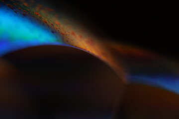 Green and blue coloured liquid edge on black background