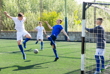 Football soccer players with ball. Footballers kicking football match on the pitch. Young teen soccer game