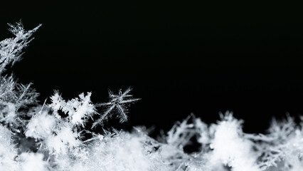 Beautiful snowflakes creating a winter wonderland with intricate frozen ice crystals on a dark background