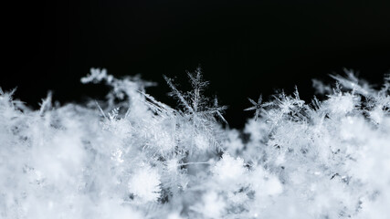 Beautiful snowflakes creating a winter wonderland with intricate frozen ice crystals on a dark...