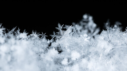 Beautiful snowflakes creating a winter wonderland with intricate frozen ice crystals on a dark background