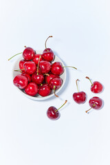 Organic cherries in a bowl set on white background