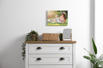 Dresser with stylish decor and houseplants near white wall indoors