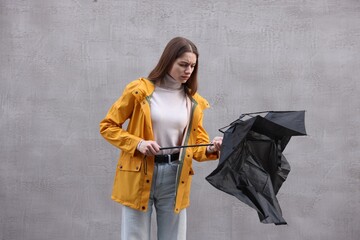 Teenage girl with black broken umbrella outdoors