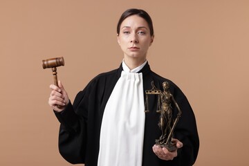 Judge with mallet and figure of Lady Justice on light brown background