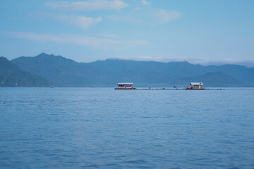 Calm Sea with Distant Boats and Blue Sky