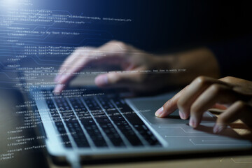 Hands typing on laptop with programming code on screen, representing software development. Perfect...