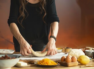 In a cozy kitchen bathed in warm light, a young girl’s hands eagerly knead dough on a floured surface
