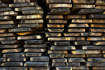 Stacked wooden planks at sawmill, lumber background texture