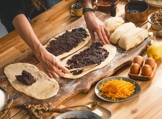 In a calm kitchen, young hands knead dough, spreading a rich filling in a tactile experience. This...