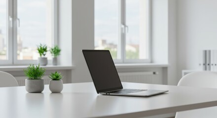 A modern workspace featuring a sleek laptop on a white table. Two small potted plants add a touch of greenery. Bright windows provide natural light.