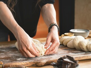 Hands of a young girl knead fresh dough in a sunlit kitchen, creating memories through the tactile...