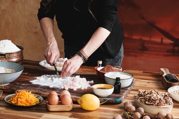 Hands are skillfully kneading dough with colorful ingredients arranged around, creating a tactile experience of learning and passing down family recipes in a cozy kitchen