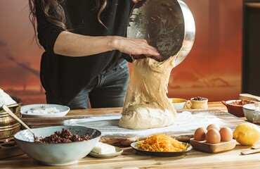 In a rustic kitchen, a young girl's hands knead dough lovingly on a wooden table, embracing the art...