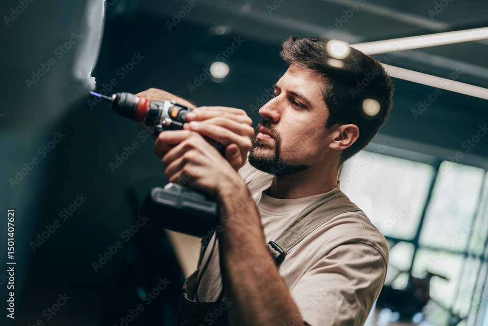 Poster craftsman working on a project in a modern workshop with tools and natural light during the day