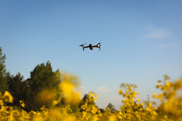 Dron, operator drona podczas pracy. Nagrywanie filmów z lotu ptaka dronem. Dron w rolnictwie. Filmy z góry. 