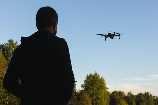 Dron, operator drona podczas pracy. Nagrywanie film&oacute;w z lotu ptaka dronem. Dron w rolnictwie. Filmy z g&oacute;ry. 