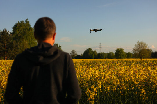 Dron, operator drona podczas pracy. Nagrywanie film&oacute;w z lotu ptaka dronem. Dron w rolnictwie. Filmy z g&oacute;ry. 