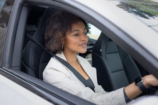 Young woman focusing while driving a modern car