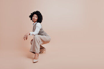 Confident Businesswoman Posing Elegantly in Stylish Formalwear Against a Beige Background