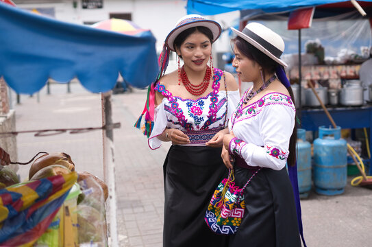 Indigenous riobamba women wearing traditional clothes chatting at market in ecuador