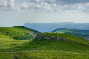 Picturesque mountain landscape on a sunny day with clouds. In the background is the famous mountain 'Ai-Petri' - one of the highest and most famous peaks of the Crimean Mountains.