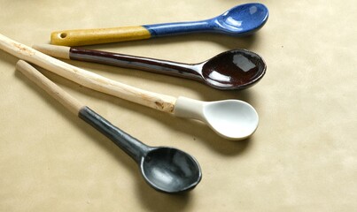 Various kinds of pottery spoons on brown background. spoon handle is made of wood. Sendok