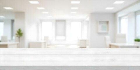 Fototapeta premium A white wooden table in a blurred office environment with lights and windows, neutral colors