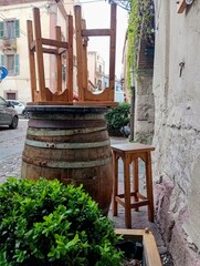 old wooden barrel and seats in a old street in Bosa,  a Sardinian town