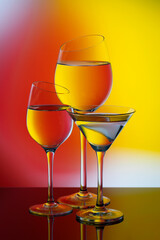 Three glass goblets on a colored gradient background