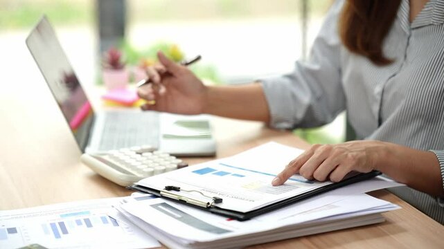 Accountant working at desk using calculator to calculate financial report in finance accounting business office concept