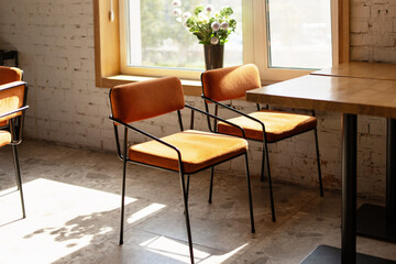 Sunlight illuminating orange chairs in modern cafe