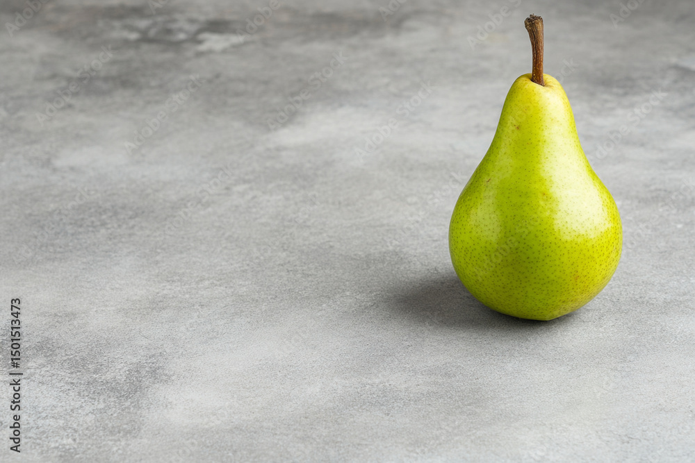 Poster fresh green pear placed on a smooth gray surface showcasing its natural color and shape in a minimal