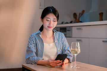 夜に一人で晩酌をする若い女性