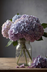 A rustic bouquet of light purple and blue hydrangeas in a glass mason jar on a wooden table, with a moody gray background. 