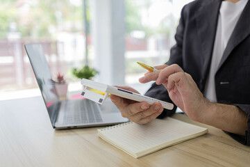 A man is typing on a laptop at a desk with a calculator, a notebook, and a stack of books. Concept of productivity and focus, as the man is working on a task that requires concentration
