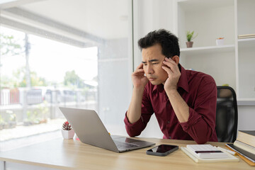 A man is typing on a laptop at a desk with a calculator, a notebook, and a stack of books. Concept of productivity and focus, as the man is working on a task that requires concentration
