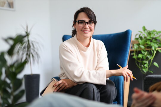 Young caucasian female therapist with glasses in office setting