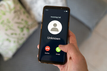Concept of incoming call from unknown number. Hand holding smartphone.