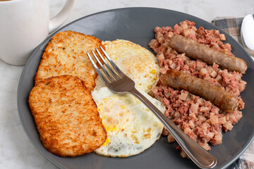 eggs ove easy  with corn beef hash and sausage