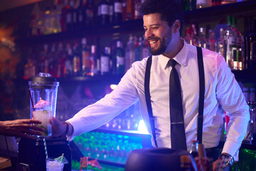 Bartender serving cocktail to customer in nightclub