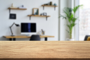 Modern home office setup featuring a wooden desk and plant in a bright, airy space