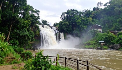 Obraz premium Majestic Waterfall Cascading Through Lush Greenery in Bolaven Plateau Laos